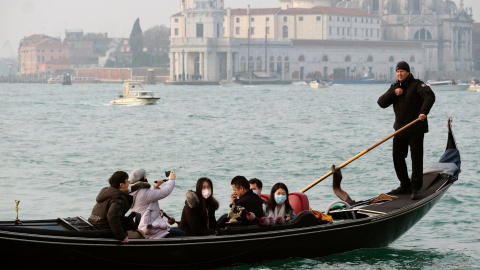Unos pasajeros en góndola por Venecia portan mascarillas mientras dan un paseo. REUTERS/Manuel Silvestri