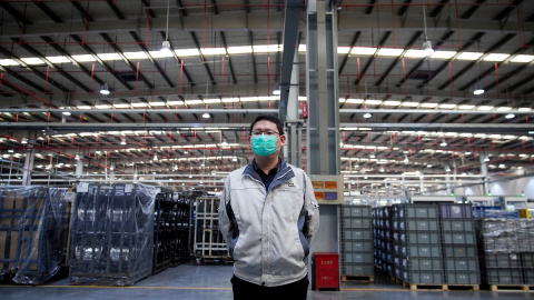 Un trabajador posa con una máscara en una fábrica de Shanghai. REUTERS/Aly Song