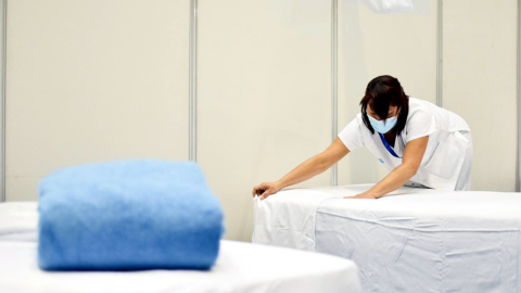 Una sanitària fent un dels llits del pavelló Olímpic de la Vall d'Hebron de Barcelona /ACN i Ajuntament de Barcelona