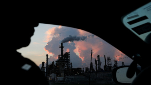 Desde su coche, un policía ve el humo de una refinería industrial de Texas. Reuters/Loren Elliott