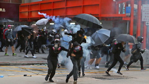Los manifestantes antigubernamentales huyeron del gas lacrimógeno durante las protestas en el Día Nacional en Hong Kong, China.EFE / EPA / FAZRY ISMAIL