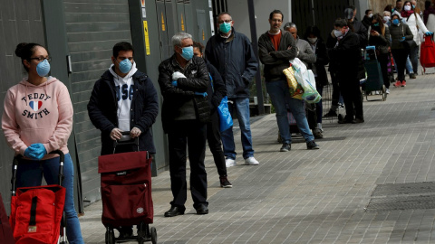 Varios clientes guardan cola para entrar en un supermercado de la Gran Via de Barcelona, este miércoles, cuando se cumple el undécimo día del estado de alarma decretado por el Gobierno por la pandemia de coronavirus. EFE/Toni Albir