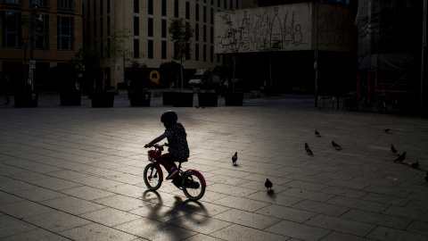 Un nen va amb la moto en un carrer de Barcelona, ja que el brot del coronavirus continua alentint-se. Jordi Boixareu / ZUMA Wire / DPA