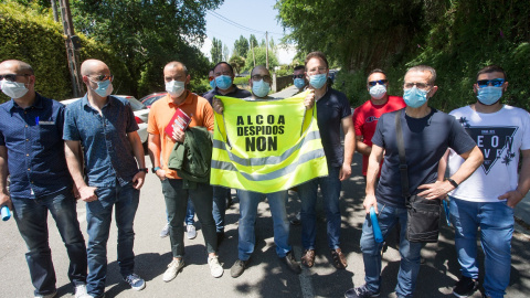 Miembros del Comité de Empresa de Alcoa San Cibrao sujetan un chaleco en el que se lee "Alcoa, Despidos Non", a la salida de la reunión entre el Comité y la directiva de la multinacional estadounidense tras el anuncio del despido colectivo