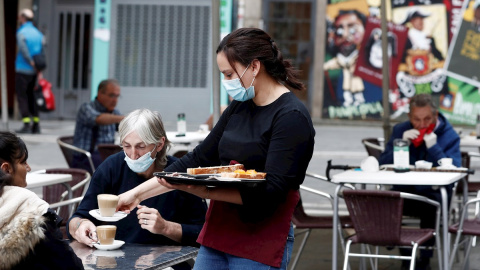 11/05/2020.- Varios clientes toman su primer café sentados en la terraza de la Plaza del Ayuntamiento de Pamplona. / EFE - JESÚS DIGES