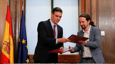 Pedro Sánchez y Pablo Iglesias en la firma del pacto del gobierno de coalición, el pasado diciembre, en el Congreso de los Diputados. REUTERS