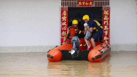 Miembros del Servicio de Rescate trabajan para evacuar a una niña atrapada por las inundaciones en Huangshan (China). /Europa Press