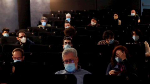 Espectadores ataviados con mascarillas asisten a la proyección de una película. EFE/Kiko Huesca/Archivo