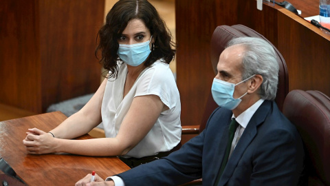 La presidenta de la Comunidad de Madrid, Isabel Díaz Ayuso, observa al consejero de Sanidad, Enrique Ruiz Escudero, durante el pleno que la Asamblea celebra este jueves en el que se debate la reprobación y cese de Ruiz Escudero, por su gest