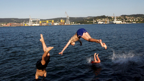 Unos jóvenes saltan al agua al atardecer en la playa del barrio de Carranza en Ferrol, Coruña, este miércoles. La Galicia de la fase 2 de desescalada disfruta del buen tiempo y de la proximidad de las playas donde disfrutan de unas temperat