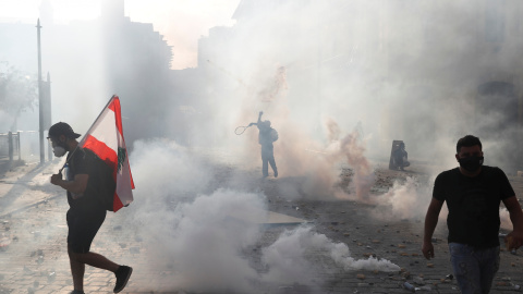 Un manifestante usa una raqueta de tenis para devolver un bote de gas lacrimógeno a la policía antidisturbios durante una protesta en Beirut, Líbano / REUTERS / Goran Tomasevic
