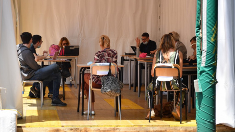 Estudiantes de secundaria realizando la aprueba de bachillerato (esame di maturita) en una carpa instalada en el patio de la escuela secundaria JF Kennedy en Roma, como medida para mantener la distancia. Tiziana FABI / AFP