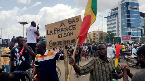 Opositores celebran las noticias sobre un supuesto golpe militar en la plaza de la Independencia de Bamako. El cartel dice:: Fin de Francia y su gobernante." REUTERS/Rey Byhre