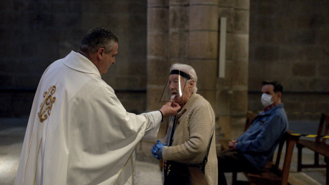 11/05/2020.- Una mujer comulga durante la celebración de misa en el interior de la catedral de Ourense. / EFE - BRAIS LORENZO