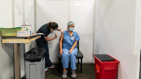 Una enfermera de la Universidad de Washignton administra la vacuna de Pfizer-BioTech a una compañera en un centro médico de la Universidad de Washington en Seattle.