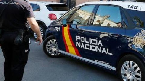 Imagen de archivo de un agente y un coche de la Policía Nacional. - EFE