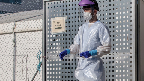 Un sanitario realiza test para detectar la covid-19 a pacientes en sus vehículos frente al hospital de campaña de La Fe de València