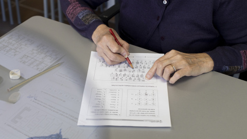 Una dona amb Alzheimer emplena una fitxa per exercitar la memòria.