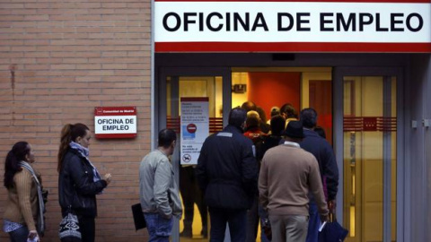 Varias personas hacen cola para entrar en una oficina de empleo en Madrid.