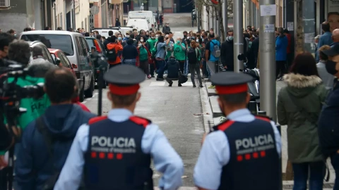 3. Dos agents dels Mossos d’Esquadra, d’esquena, miren cap als membres de la PAH concentrats per evitar un desnonament previst al carrer Borràs, a Nou Barris, el 4 de noviembre de 2020.