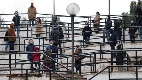 Varias personas hacen cola ante un laboratorio para hacerse una prueba PCR este martes en Madrid, dos días antes de Nochebuena.