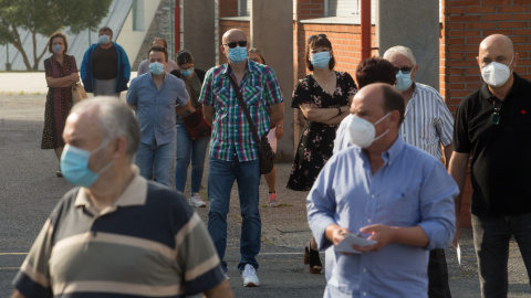 Varias personas hacen cola para votar en las elecciones autonómicas de Galicia en la población de Burela, en la comarca de A Mariña