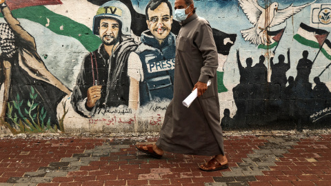 Un palestino pasa frente a un mural de periodistas asesinados en 2014 entre Hamas e Israel en Gaza.