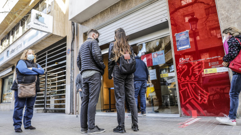 Varias personas con cita previa esperan para entrar en una oficina del SEPE (antiguo INEM), en Valencia, Comunidad Valenciana (España), a 12 de febrero de 2021.