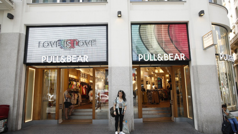 Una joven en la entrada de una de las tiendas de Pull&Bear, una de las marcas de Inditex, en la Gran Vía de Madrid. E.P./Eduardo Parra