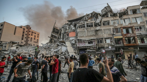 Los palestinos inspeccionan los escombros del destruido Al-Shorouq twoer después de un ataque israelí en la ciudad de Gaza, el 12 de mayo de 2021.