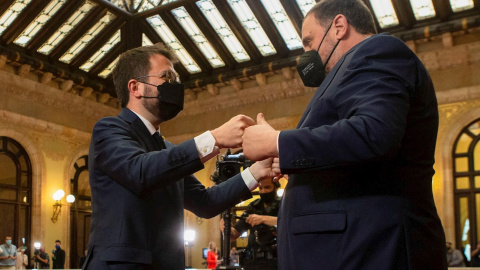 El nuevo presidente de la Generalitat, Pere Aragonès (i) es felicitado por del presidente de ERC, Oriol Junqueras (d) tras ser elegido por mayoría absoluta en la segunda jornada del debate de investidura celebrado en el Parlament este viern