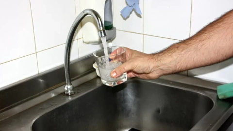 Una mà omplint un got d'aigua d'una aixeta a la Bisbal d'Empordà després de que s'hagin retirat les restriccions. 24 d'agost del 2016.