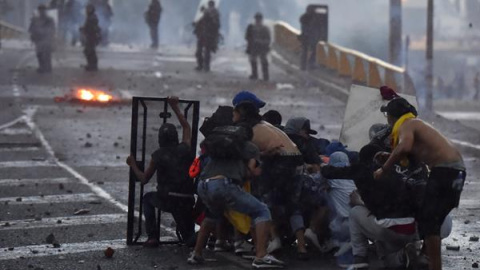 Jóvenes de la Primera Línea se enfrentan con policías del Esmad, el 18 de mayo de 2021, durante una jornada de protestas en Yumbo, Valle del Cauca (Colombia).