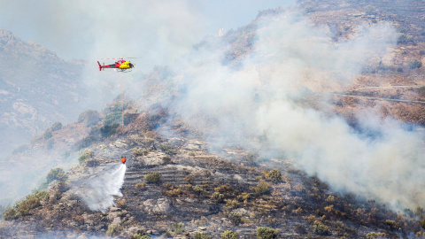 Un helicóptero en labores de extinción del incendio declarado este viernes en el parque natural del Cap de Creu.