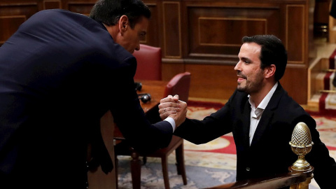 El coordinador de Izquierda Unida, Alberto Garzón (d), saluda al candidato a la Presidencia del Gobierno, Pedro Sánchez (i), tras su intervención ante el pleno del Congreso de los Diputados en la primera jornada de la sesión de investidura