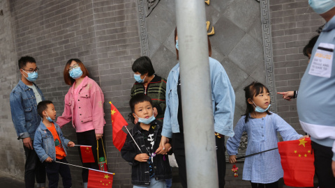 05/10/2021 Los niños sostienen banderas chinas cerca de la Ciudad Prohibida durante las vacaciones del Día Nacional tras un brote de la enfermedad por coronavirus