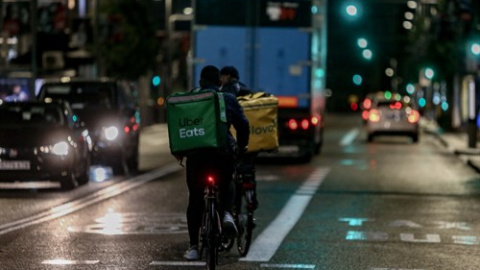 Foto de archivo. Un rider de Uber Eats y de Glovo circulan por las calles de Madrid.