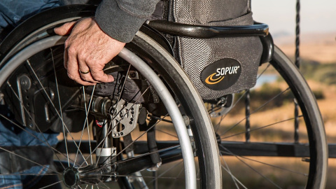 Fotografía detalle de una persona en silla de ruedas.