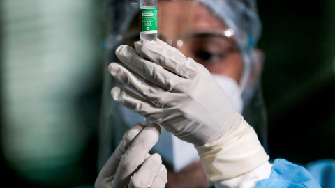 Imagen de una trabajadora sanitaria y una dosis contra la covid.