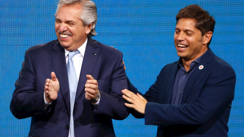 El presidente de Argentina, Alberto Fernández, y el gobernador de la provincia de Buenos Aires, Axel Kisilof, saludan al público de su búnker tras conocer los resultados de las elecciones.