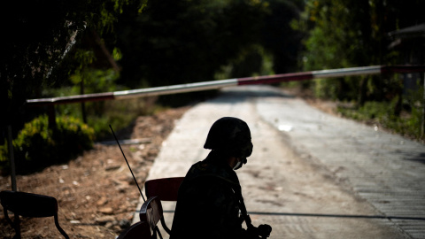 24/12/2021 Un soldado tailandés se sienta frente a una carretera bloqueada que conduce a la frontera entre Tailandia y Myanmar, donde aún continúan los combates