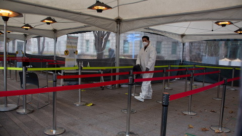Un trabajador surcoreano rocía desinfectante como precaución contra la propagación del coronavirus en una estación de pruebas COVID-19 improvisada en Seúl, Corea del Sur, el 27 de diciembre de 2021.