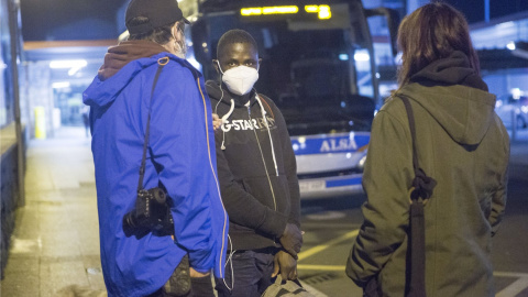 Una persona migrante es recibida por voluntarios de la red de acogida tras llegar a la estación de autobuses de Irún, en Gipuzkoa.