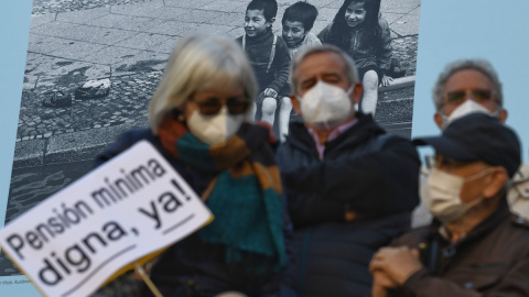 Un grupo de personas con un cartel durante una manifestación que reclama el blindaje de las pensiones en la Constitución, a 13 de noviembre de 2021, en Madrid.