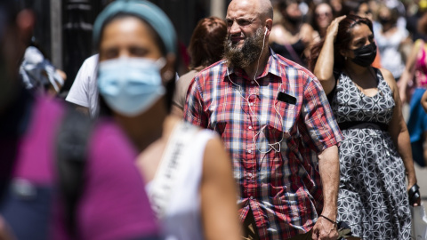 Un hombre pasea sin mascarilla por el centro de Madrid, durante el primer día en el que no es obligado el uso de la mascarilla en exteriores desde el inicio de la pandemia, a 26 de junio de 2021, en Madrid.