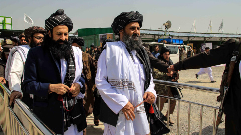 El mulá Abdul Ghani Baradar (der.), primer viceministro principal, asiste a la ceremonia de inauguración durante una exposición en Kabul, Afganistán, el 26 de marzo de 2022, en la que se exhiben productos agrícolas de diferentes provincias