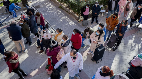 Varias personas hacen cola para recibir alimentos de la Fundación Madrina, en la plaza de San Amaro, a 7 de enero de 2022, en Madrid (España).