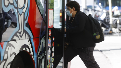 18/04/2022-Una mujer con mascarilla sube al autobús este lunes 18 de abril en Madrid