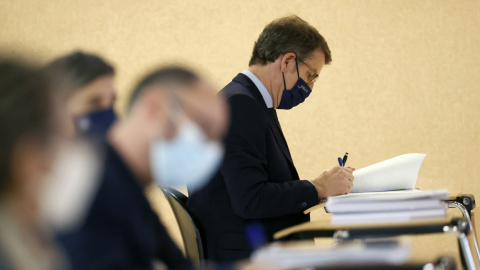 El presidente de la Xunta, Alberto Núñez Feijóo, sentado entre los periodistas durante la intervención del conselleiro de Economía, Miguel Corgos, durante la rueda de prensa posterior al Consello de la Xunta, en Santiago de Compostela. EFE/