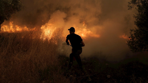 Un voluntario local en labores de extinción de un incendio en la localidad de Istiaia, en la isla griega de Eubea.